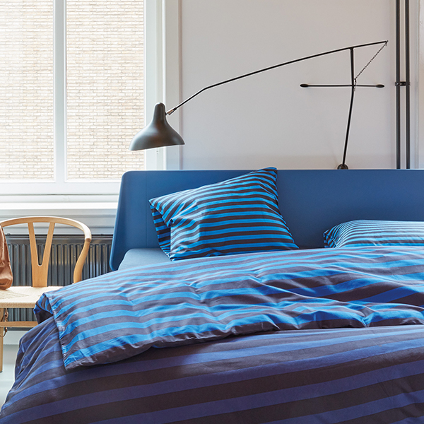 Yves duvet cover on blue essential bed